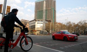 Un home espera creuar en bicicleta el pas de vianants, a tocar de la plaça Cinc d'Oros de Barcelona. ACN/Blanca Blay