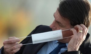 El presidente de Brasil, Jair Bolsonaro, se pone una mascarilla durante una ceremonia oficial, el 9 de junio de 2020, en el Palacio do Alvorada. EFE/ Joédson Alves.