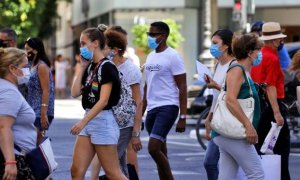 Personas en la calle con mascarilla / EFE