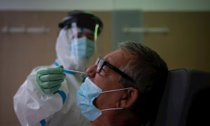 Una profesional sanitaria realiza una prueba PCR a un paciente. EFE/Enric Fontcuberta