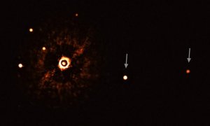 Estrella TYC 8998-760-1 (con su luz bloqueada) y sus dos exoplanetas (marcados con flechas). Los otros puntos brillantes son estrellas del fondo. / ESO/Bohn et al.