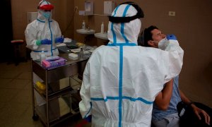 Una profesional sanitaria realiza una prueba PCR a un paciente. EFE/Enric Fontcuberta/Archivo