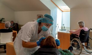 Una trabajadora atiende a una anciana en una residencia. EFE/ROMÁN G. AGUILERA/Archivo