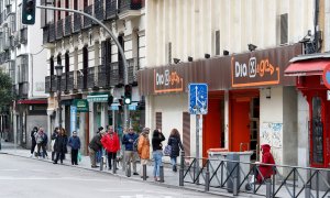 Varias personas esperan en una cola para entrar en un supermercado Dia, en Madrid, durante el estado de alarma. E.P./Óscar J.Barroso