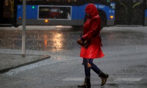 Una mujer camina por la calle durante la tormenta registrada esta mañana en Madrid. EFE/ Fernando Alvarado