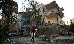 Una mujer caminando por los restos de la explosión en Beirut. / REUTERS