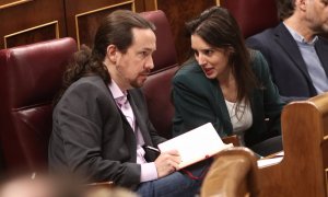 Pablo Iglesias e Irene Montero, hablan en sus escaños en el Congreso de los Diputados durante la primera sesión del debate de investidura de Pedro Sánchez, en enero de 2020. E.P./Eduardo Parra