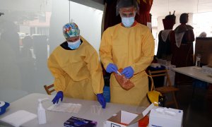 Dos sanitaris preparen un cribatge massiu de PCR. ACN