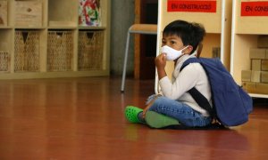 Un alumne d'infantil de l'Institut Escola Costa i Llobera, assegut amb mascareta, esperant per entrar a l'aula. Blanca Blay