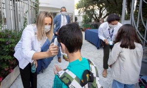Una trabajadora toma la temperatura a un niño a la entrada del colegio privado internacional American School of Barcelona, en Esplugues de Llobregat (Barcelona). EFE/ Marta Perez/Archivo