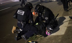 La policía detiene a un manifestante en la centésima noche consecutiva de protestas contra la violencia policial y la desigualdad racial, en Portland. REUTERS / Carlos Barria