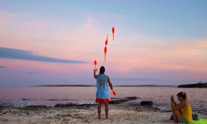 Una hombre realiza malabares al atardecer en la playa de Punta Prima en Menorca, Baleares, este miércoles. EFE/ David Arquimbau Sintes