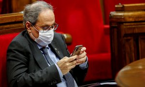 El presidente de la Generalitat, Quim Torra, consulta su dispositivo móvil durante el debate de política general que anualmente celebra el Parlament. /EFE