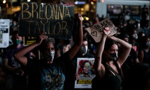 Gente con pancartas durante una marcha tras el anuncio de una sola acusación en el caso Breonna Taylor, en el distrito de Brooklyn de la ciudad de Nueva York. REUTERS / Jeenah Moon