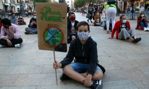 Manifestant amb una pancarta reivindicativa en la protesta organitzada a Tarragona per denunciar l'emergència climàtica. ACN/Mar Rovira