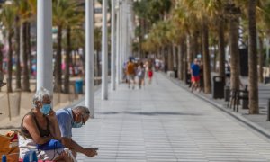 Dos personas descansan en el paseo marítimo de Benidorm, Alicante el 27 de septiembre de 2020. Lars Ter Meulen / Europa Press
