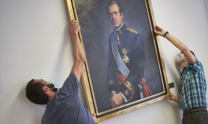 Dos operarios retiran del retrato del rey emérito Juan Carlos I de la Sala de Gobierno del Legislativo foral del Parlamento de Navarra. Eduardo Sanz / Europa Press / Archivo