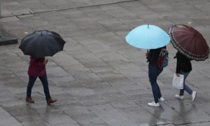 Escolares se protegen de la lluvia con paraguas en Bilbao / EFE