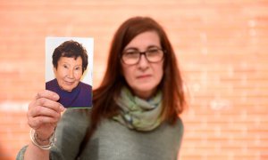 La hija de María Jesús sujetando una fotografía de su madre.