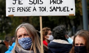 Una mujer sostiene una pancarta mientras asiste a un homenaje a Samuel Paty, el profesor de francés que fue decapitado en las calles del suburbio parisino de Conflans St Honorine, Francia. REUTERS / Pascal Rossignol / Archivo