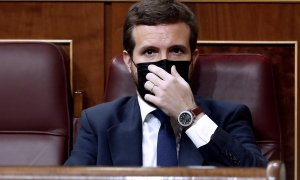 El líder del Partido Popular, Pablo Casado, se coloca la mascarilla mientras asisten a la moción de censura presentada por Vox al gobierno de coalición en el Congreso de los Diputados este miércoles. EFE/Mariscal