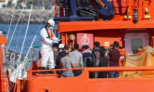 el personal de Salvamento Marítimo reparte mascarillas a los 14 inmigrantes de origen magrebí que rescataron este jueves en aguas cercanas a Gran Canaria. EFE/ Elvira Urquijo A.