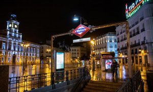 Una pareja se despide junto a la entrada del Metro de la Puerta del Sol, anoche, en la primera jornada de toque de queda en la capital.