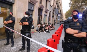 El cordó policial en primer terme i de les persones concentrades a les portes d'un habitatge per evitar el desnonament. Miquel Codolar | ACN