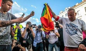Varias personas se disponen a quemar una bandera LGTBI en Polonia.
