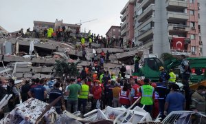 Ciudadanos buscan sobrevivientes en un edificio derrumbado afectado por el terremoto en la provincia costera de Izmir.