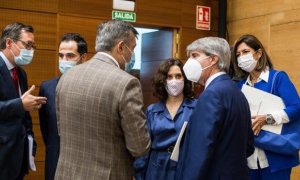 La presidenta de la Comunidad, Isabel Díaz Ayuso, habla con su equipo en el pleno de la Asamblea de Madrid - EP