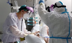 Personal sanitario atienden a un paciente en la Unidad de Cuidados Intensivos del Hospital La Fé de Valencia.