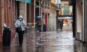 Transeúntes por la calle Sagasta durante una jornada de lluvia. En Sevilla (Andalucía, España), a 22 de octubre de 2020.