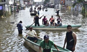 Habitantes del estado de salvan algunos de sus enseres en una avenida inundada por el huracán Eta en Tabasco, México.