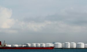 Un barco amarrado cerca de tanques de almacenamiento en una refinería de petróleo frente a la costa de Singapur. REUTERS/Vivek Prakash