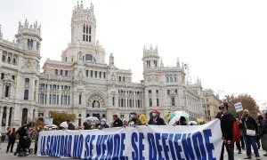 Participantes tras una pancarta en la manifestación de la Marea blanca en defensa de la sanidad pública que tiene lugar este domingo en Madrid, entre Neptuno y la plaza de Colón.