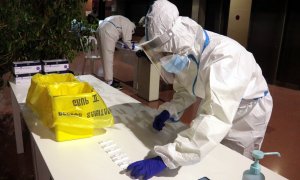 Un professional sanitari dipositant una mostra en un test d'antígens al pavelló Onze de Setembre de Lleida.