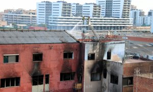 L'edifici on s'ha produït l'incendi de Badalona, amb bombers treballant.
