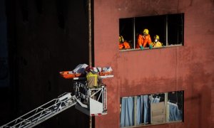 Bomberos retiran el cadáver de una de las personas fallecidas en el incendio de ayer en la nave okupada del barrio de Gorg, en Badalona, Barcelona, Catalunya