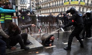 Un agente de policía francés echa spray sobre un manifestante en el suelo.
