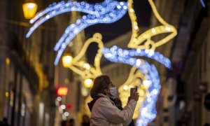 Una mujer bajo la iluminación navideña.