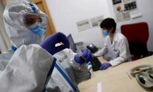 Imagen de archivo de un trabajador sanitario con una muestra de un test de coronavirus.