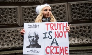 Una mujer con una pancarta de apoyo a Julian Assange frente a la corte penal londinense de Old Bailey.