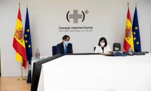 El ministro de Sanidad, Salvador Illa (i), preside por videoconferencia, junto con la ministra de Política Territorial y Función Pública, Carolina Darias (d), la reunión del Consejo Interterritorial del Sistema Nacional de Salud, este lunes en Madrid.