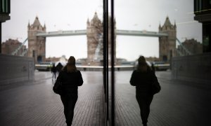 Una mujer camina cerca del Tower Bridge en Londres, Reino Unido