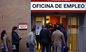 Varias personas hacen cola para entrar en una oficina de empleo en Madrid.