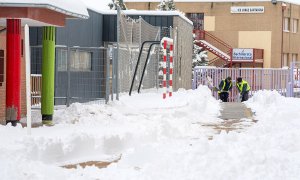 Operarios trabajando en un colegio de Ávila este domingo para quitar la nieve acumulada.