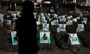 Un yemení camina entre los retratos de las tumbas de los últimos yemeníes, que supuestamente fueron asesinados en la guerra en curso del país, durante el aniversario de la Semana de los Mártires celebrada por los hutíes en un cementerio de Yemen