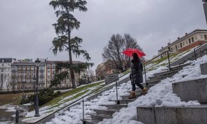 Una viandante baja una escalinata cerca del madrileño Museo del Prado bajo la lluvia, este miércoles