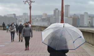 Una persona pasea con paraguas en el Paseo Marítimo, el mismo día del paso de la borrasca Justine convertida en ciclogénesis explosiva en A Coruña, Galicia.